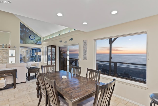 dining space with a water view and lofted ceiling