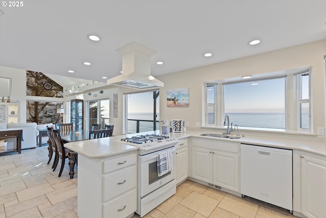 kitchen with a water view, white cabinets, white appliances, and kitchen peninsula