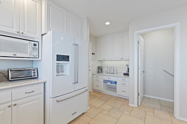 kitchen featuring white appliances and white cabinets