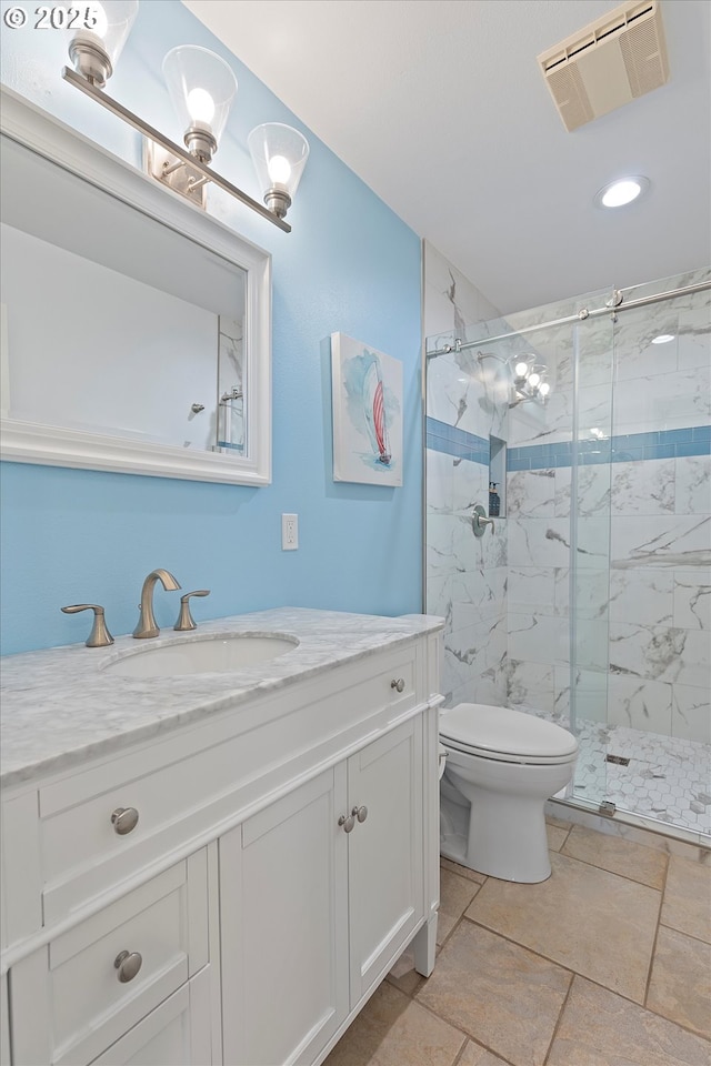 bathroom with vanity, toilet, and a shower with shower door