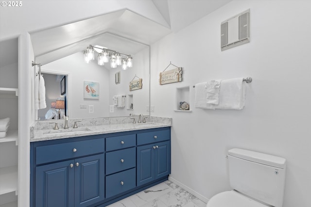 bathroom featuring vanity, lofted ceiling, and toilet