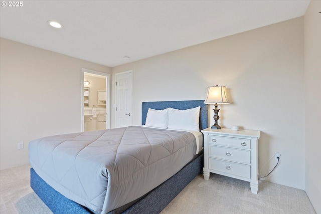 bedroom with connected bathroom and light colored carpet