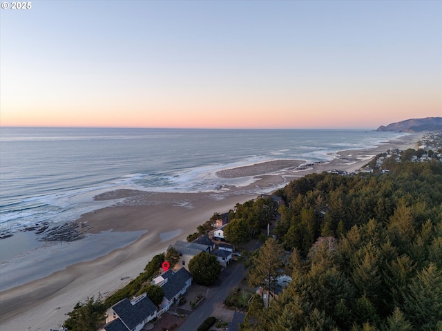 aerial view at dusk featuring a water view