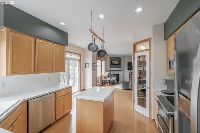 7874 Jani Ct NE, Keizer, OR 97303 - kitchen featuring appliances with stainless steel finishes, light brown cabinetry, light wood finished floors, a fireplace, and recessed lighting