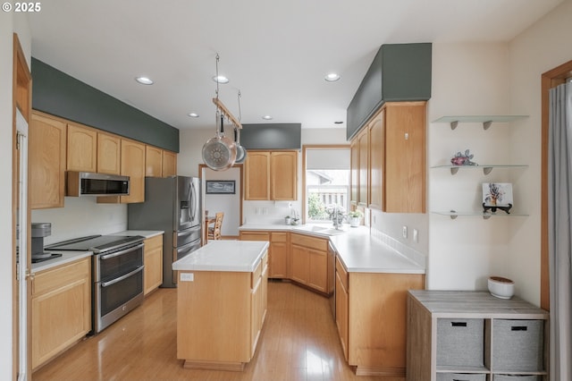 7874 Jani Ct NE, Keizer, OR 97303 - kitchen featuring appliances with stainless steel finishes, a kitchen island, light countertops, light wood finished floors, and light brown cabinetry