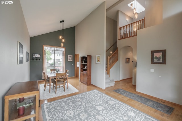 7874 Jani Ct NE, Keizer, OR 97303 - dining room with arched walkways, wood finished floors, high vaulted ceiling, stairs, and baseboards