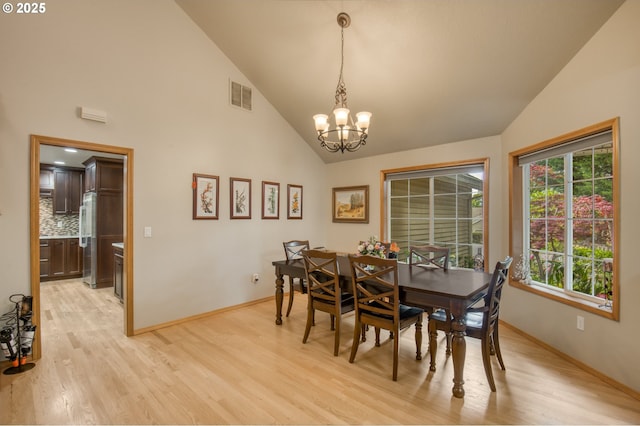 5200 NW 168th Pl, Portland, OR 97229 - dining area featuring high vaulted ceiling, a chandelier, baseboards, and light wood-type flooring
