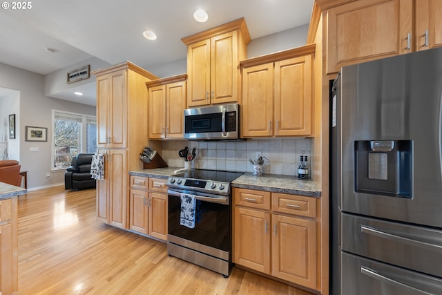 kitchen featuring stone counters, stainless steel appliances, decorative backsplash, light wood-type flooring, and light brown cabinets