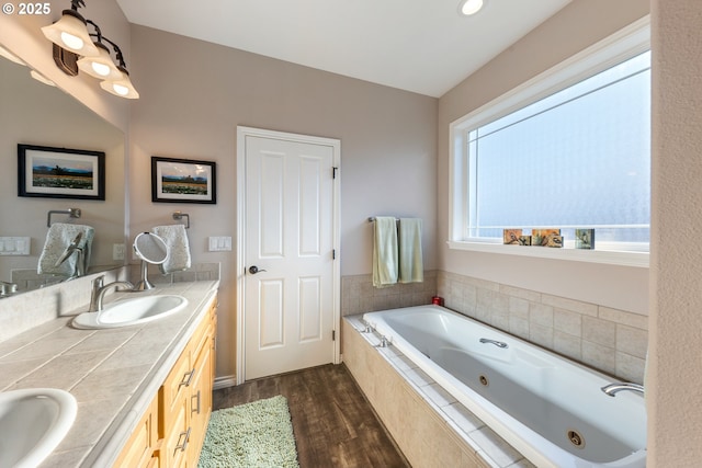 bathroom featuring vanity, wood-type flooring, and tiled bath