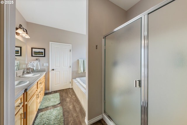 bathroom featuring plus walk in shower, hardwood / wood-style floors, and vanity