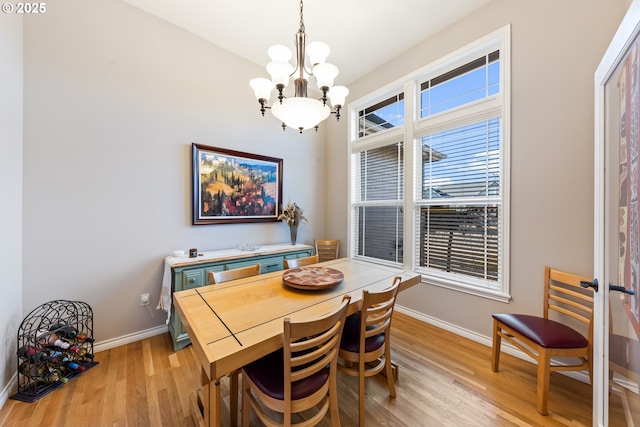 dining area with an inviting chandelier and light hardwood / wood-style flooring