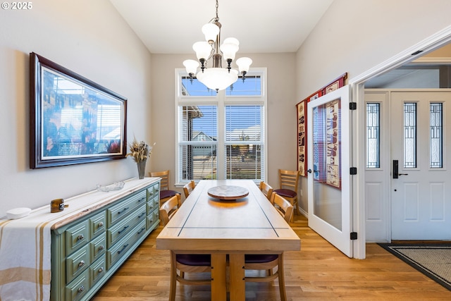 dining area with a notable chandelier and light hardwood / wood-style floors