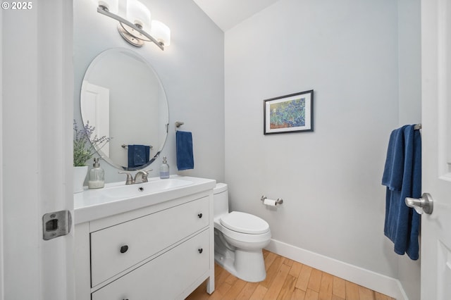 7540 SW Becky Ct, Beaverton, OR 97007 - half bath featuring baseboards, vanity, wood finished floors, and toilet