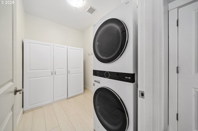 7540 SW Becky Ct, Beaverton, OR 97007 - laundry area featuring stacked washing machine and dryer, cabinet space, and baseboards
