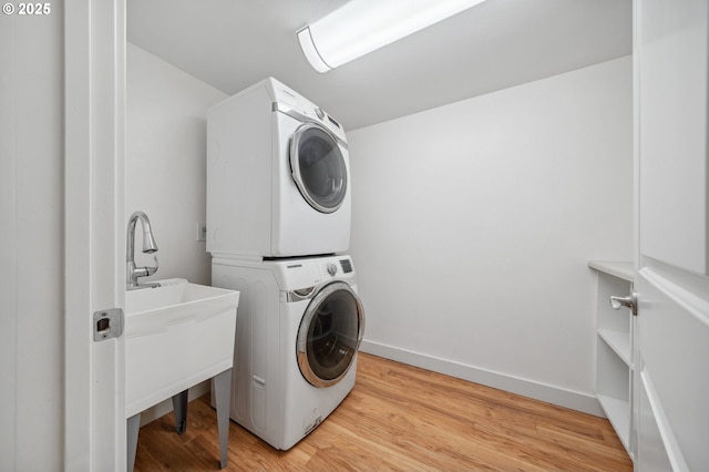 7540 SW Becky Ct, Beaverton, OR 97007 - washroom with stacked washing machine and dryer, light wood-type flooring, and baseboards