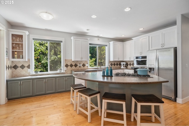 7540 SW Becky Ct, Beaverton, OR 97007 - kitchen featuring appliances with stainless steel finishes, a kitchen breakfast bar, backsplash, and recessed lighting