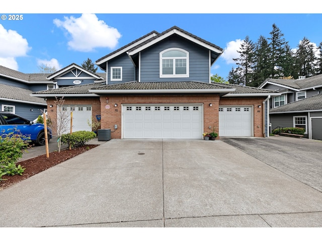 view of property with brick siding, an attached garage, and concrete driveway