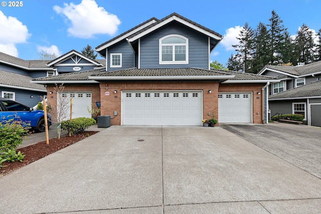 30366 SW Ruth St Unit 70, Wilsonville, OR 97070 - view of property with brick siding, an attached garage, and concrete driveway