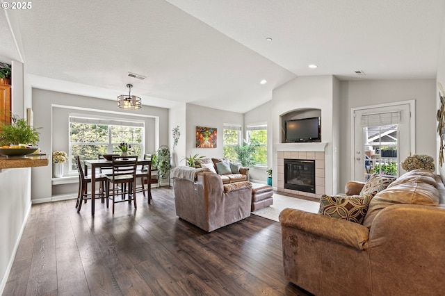 30366 SW Ruth St Unit 70, Wilsonville, OR 97070 - living area with a tiled fireplace, visible vents, vaulted ceiling, and dark wood-style floors