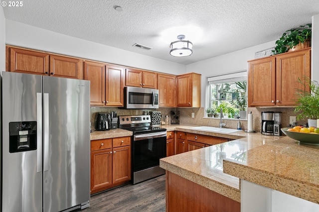 30366 SW Ruth St Unit 70, Wilsonville, OR 97070 - kitchen featuring brown cabinets, appliances with stainless steel finishes, a sink, tile countertops, and dark wood-type flooring