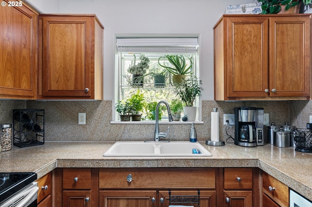 kitchen featuring tile countertops, brown cabinetry, and a sink