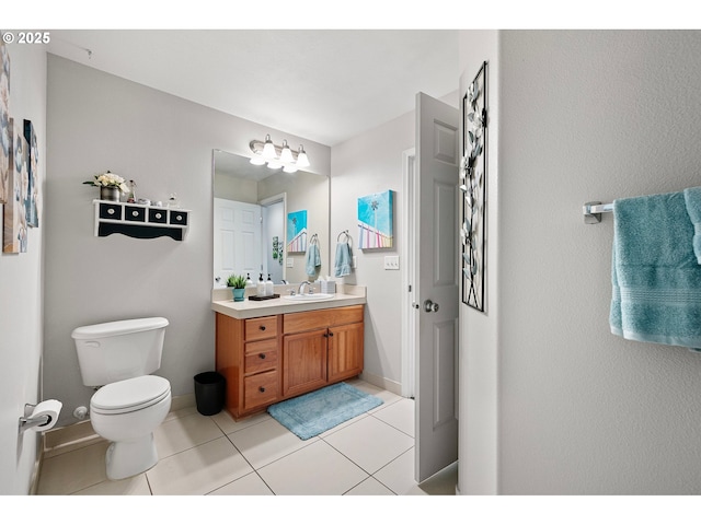 bathroom with toilet, baseboards, tile patterned flooring, and vanity