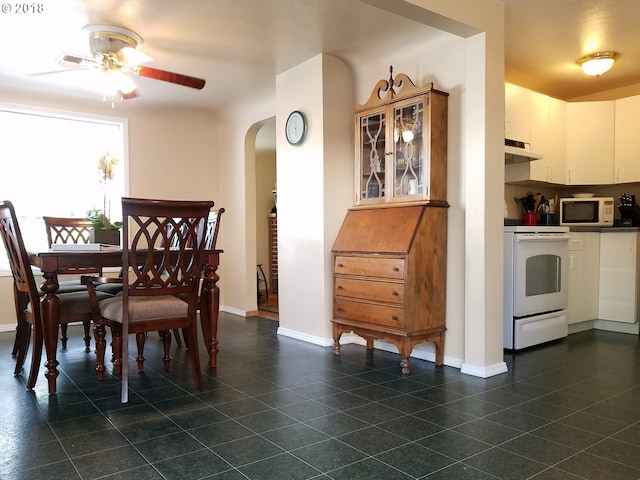 335 Kourt Dr, Eugene, OR 97404 - dining space with arched walkways, a ceiling fan, and dark tile patterned flooring