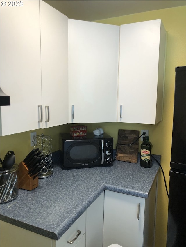 335 Kourt Dr, Eugene, OR 97404 - kitchen featuring black appliances, white cabinetry, and dark countertops