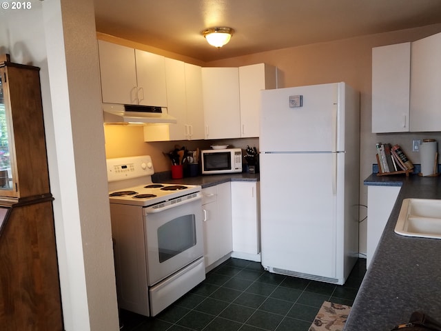 335 Kourt Dr, Eugene, OR 97404 - kitchen with white appliances, under cabinet range hood, dark tile patterned floors, and dark countertops