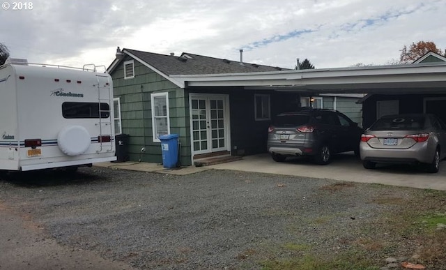 335 Kourt Dr, Eugene, OR 97404 - back of property featuring french doors, an attached carport, and roof with shingles