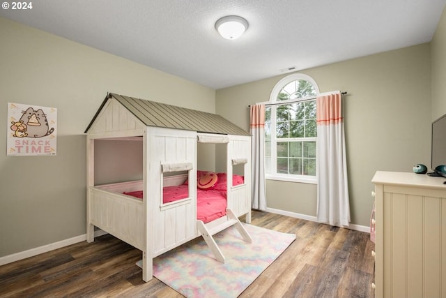 bedroom featuring dark wood-type flooring and a textured ceiling