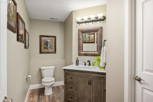 bathroom featuring wood-type flooring, toilet, and vanity