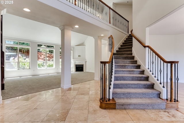 3169 Tanner Park Dr, Eugene, OR 97405 - staircase featuring carpet floors, a towering ceiling, a fireplace, recessed lighting, and tile patterned flooring