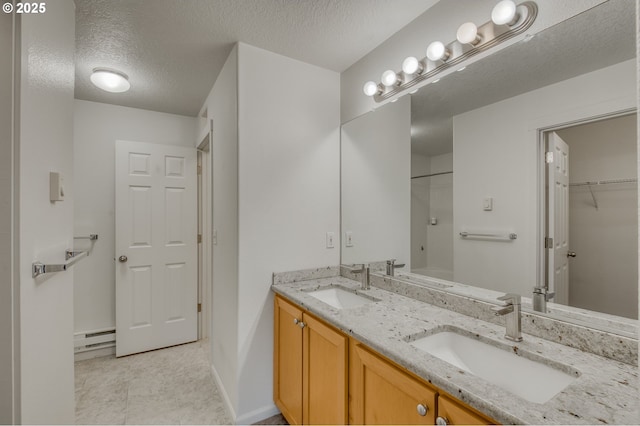 bathroom with vanity, a textured ceiling, and a baseboard radiator