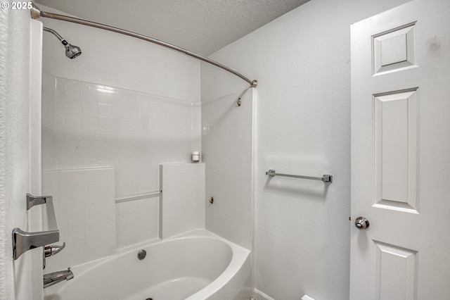 bathroom featuring a textured ceiling and bathing tub / shower combination