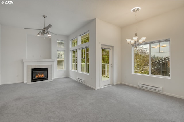 unfurnished living room with ceiling fan with notable chandelier, a high ceiling, carpet, a baseboard heating unit, and a tiled fireplace