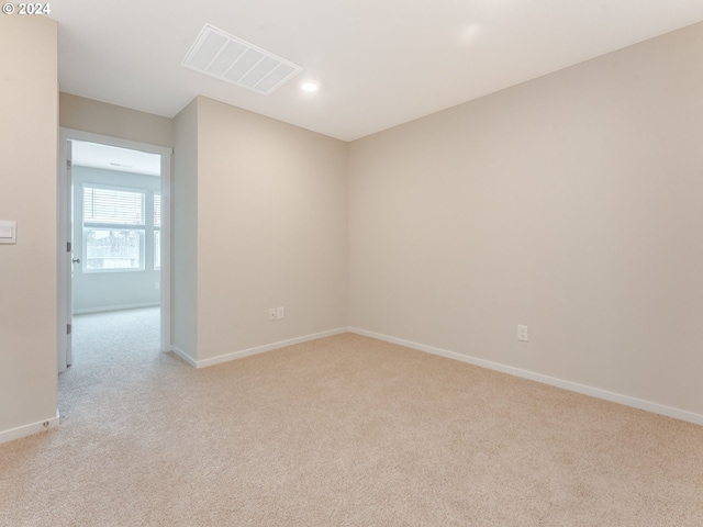 spare room featuring light colored carpet