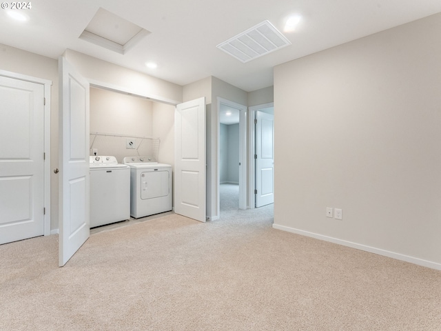 clothes washing area with light carpet and washing machine and clothes dryer