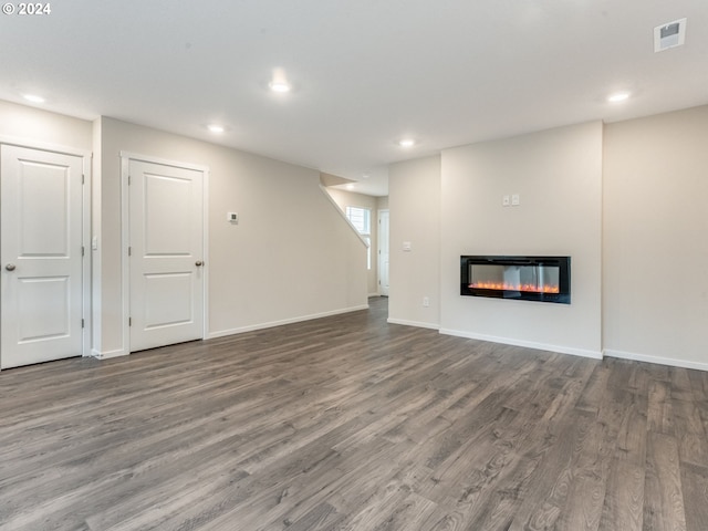 unfurnished living room with dark hardwood / wood-style flooring