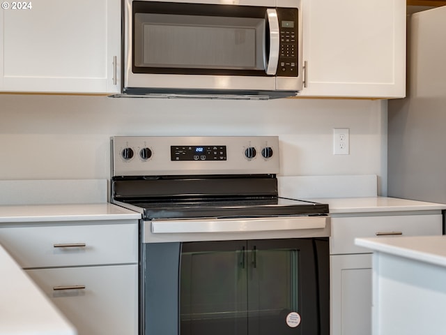 kitchen with appliances with stainless steel finishes and white cabinetry