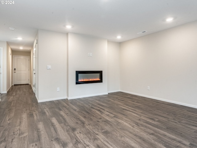 unfurnished living room with dark wood-type flooring