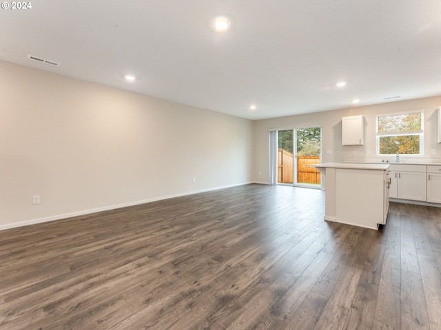 unfurnished living room with sink and dark hardwood / wood-style flooring