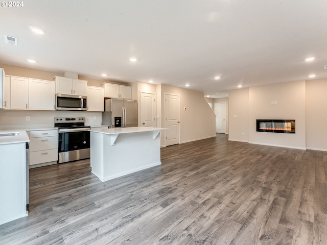 kitchen featuring white cabinets, light wood-type flooring, stainless steel appliances, and a center island