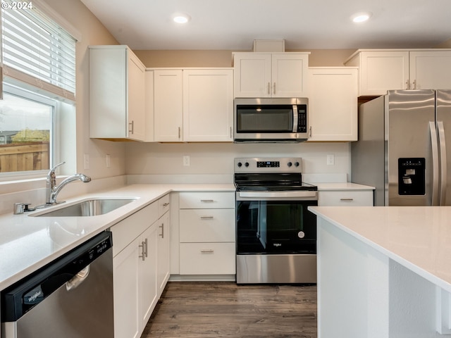 kitchen with sink, white cabinets, appliances with stainless steel finishes, and dark hardwood / wood-style floors