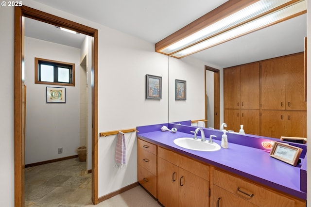 3820 SW Scholls Ferry Rd, Portland, OR 97221 - bathroom with baseboards, stone finish flooring, and vanity