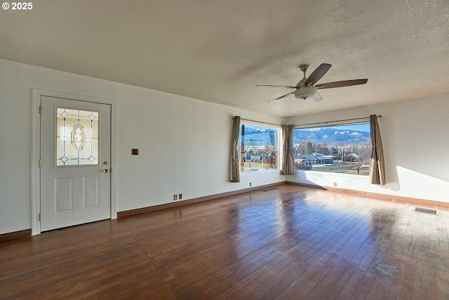 entrance foyer with dark hardwood / wood-style flooring, a textured ceiling, and ceiling fan