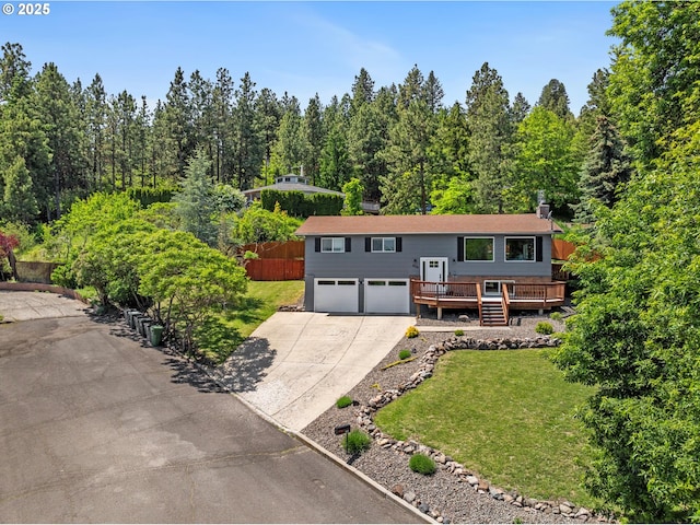 406 Balsa St, La Grande, OR 97850 - split foyer home with an attached garage, a deck, driveway, and a front lawn