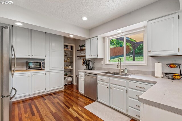 406 Balsa St, La Grande, OR 97850 - kitchen featuring appliances with stainless steel finishes, a sink, light countertops, dark wood finished floors, and a textured ceiling