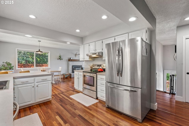 406 Balsa St, La Grande, OR 97850 - kitchen featuring stainless steel appliances, a textured ceiling, under cabinet range hood, light countertops, and dark wood-type flooring