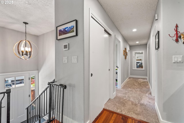 406 Balsa St, La Grande, OR 97850 - hall featuring a textured ceiling, a chandelier, baseboards, wood finished floors, and recessed lighting